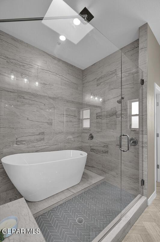 bathroom with a stall shower and a freestanding tub