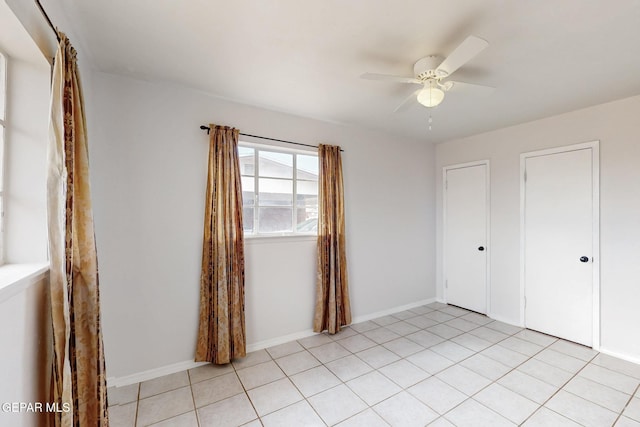 unfurnished bedroom with baseboards, a ceiling fan, and light tile patterned flooring