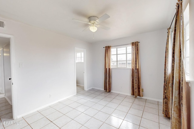 spare room with visible vents, ceiling fan, baseboards, and light tile patterned floors