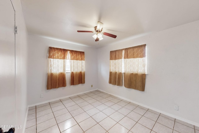 empty room with ceiling fan and baseboards