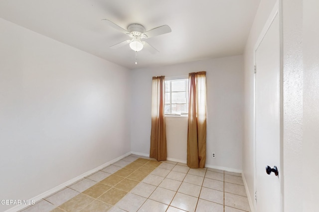 empty room featuring baseboards, a ceiling fan, and light tile patterned flooring