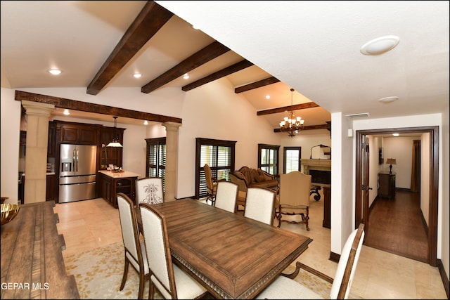 dining room with beam ceiling, decorative columns, a notable chandelier, a fireplace, and visible vents