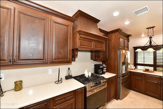 kitchen featuring visible vents, appliances with stainless steel finishes, hanging light fixtures, light countertops, and premium range hood