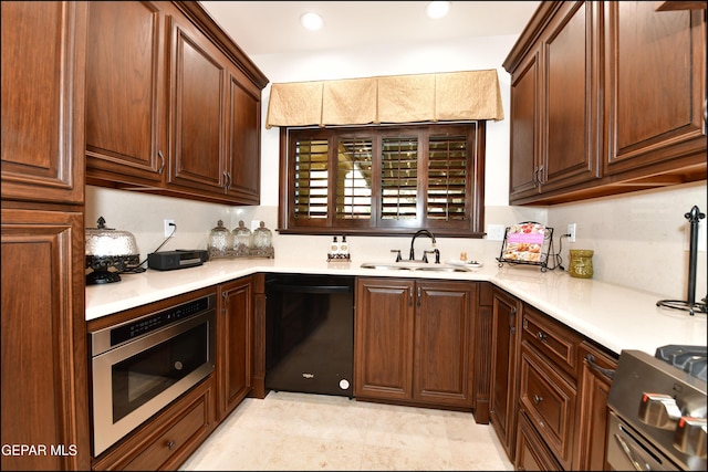 kitchen featuring wall oven, dishwasher, gas range, light countertops, and a sink