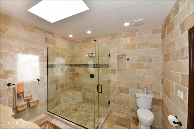 bathroom with toilet, a stall shower, a skylight, and recessed lighting