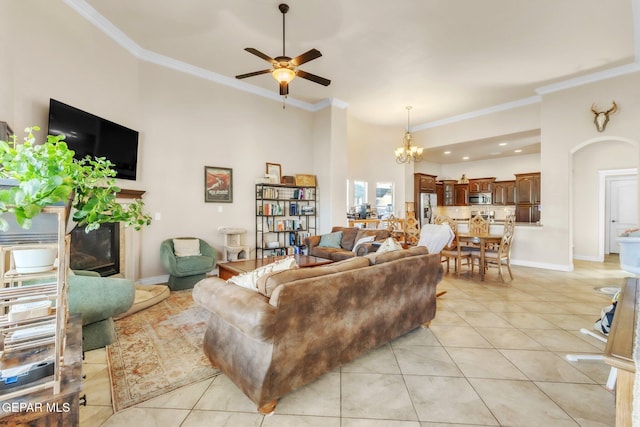 living room with crown molding, light tile patterned flooring, a fireplace, and baseboards