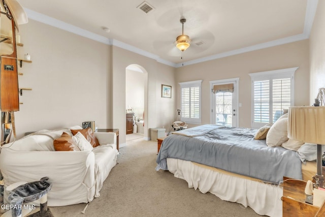 bedroom with arched walkways, crown molding, light colored carpet, visible vents, and ensuite bath