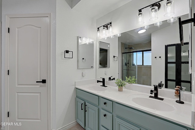 full bathroom with double vanity, a stall shower, and a sink