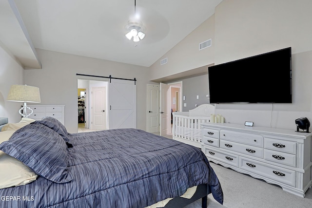 bedroom with carpet floors, high vaulted ceiling, a barn door, and visible vents