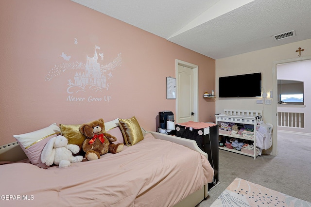 bedroom featuring carpet floors, visible vents, and a textured ceiling