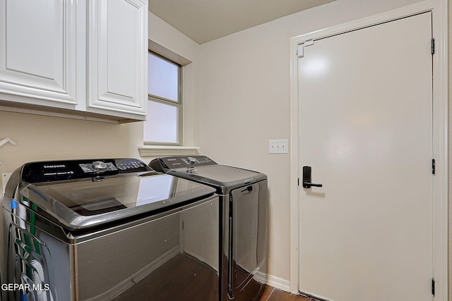 washroom with dark wood-type flooring, washing machine and dryer, cabinet space, and baseboards