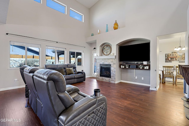 living room with a healthy amount of sunlight, dark wood finished floors, and a notable chandelier