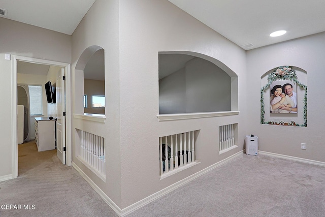 hall featuring carpet, visible vents, and baseboards