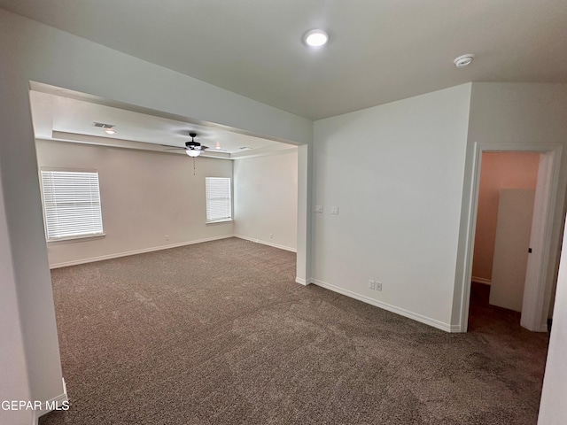 carpeted empty room with ceiling fan, visible vents, and baseboards