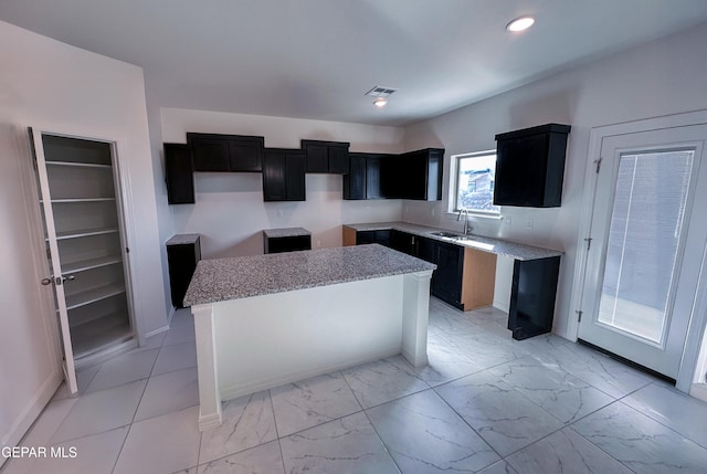 kitchen featuring marble finish floor, visible vents, dark cabinets, and recessed lighting