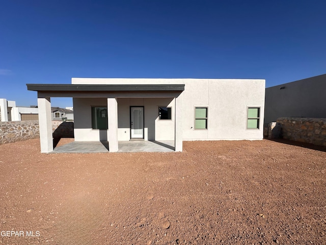 back of property featuring a patio and stucco siding