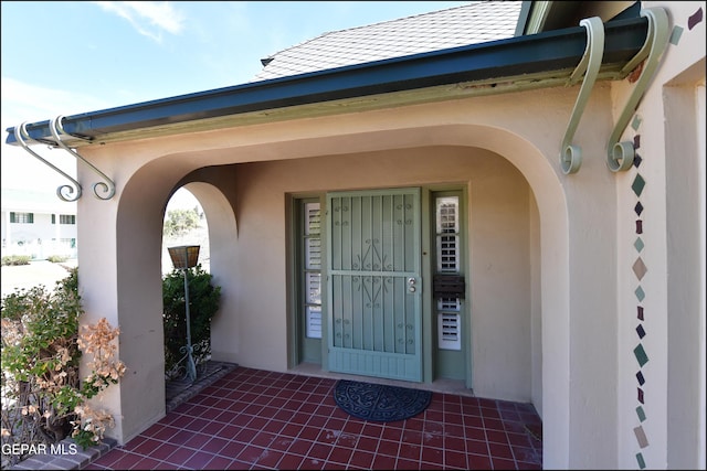 view of exterior entry with stucco siding