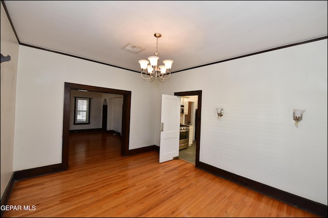 unfurnished room with a notable chandelier, visible vents, baseboards, light wood-style floors, and crown molding