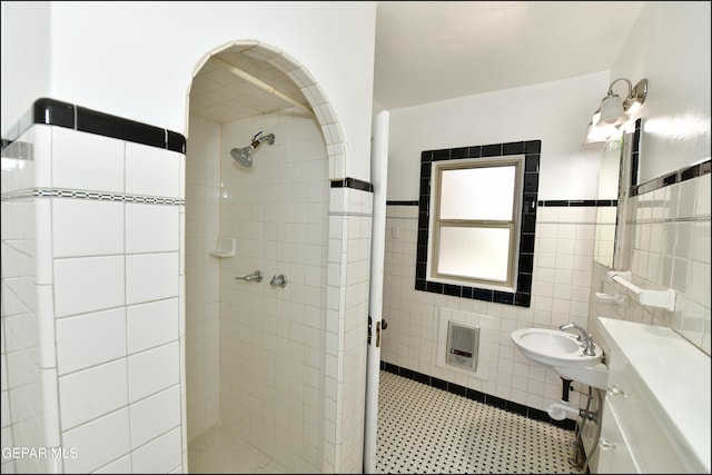 bathroom featuring a stall shower, wainscoting, and tile walls