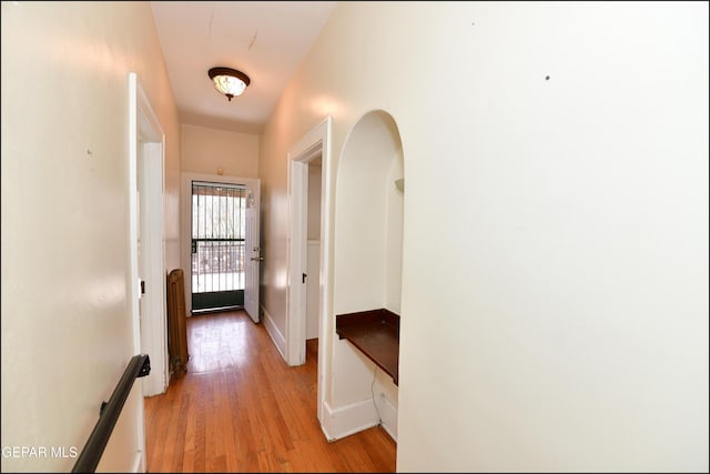 corridor with light wood-style floors and baseboards