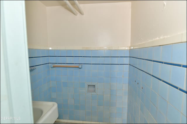 bathroom with wainscoting and tile walls