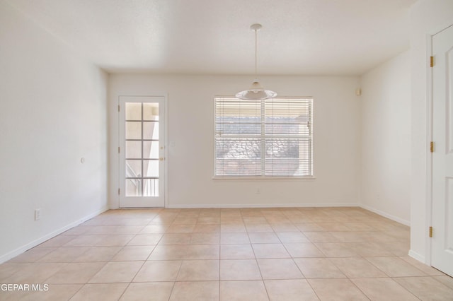 empty room featuring light tile patterned floors and baseboards