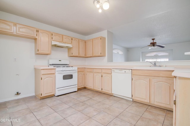 kitchen featuring under cabinet range hood, light brown cabinets, plenty of natural light, and white appliances