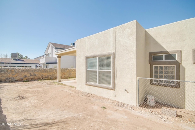 view of home's exterior featuring stucco siding and fence