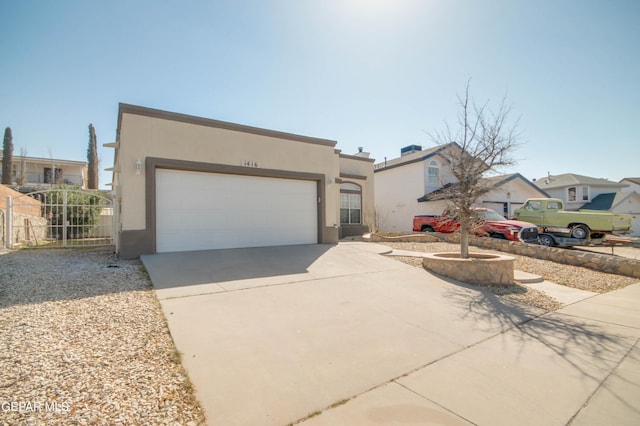 view of front facade with stucco siding, a gate, fence, concrete driveway, and a garage