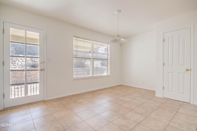 empty room featuring light tile patterned floors and baseboards