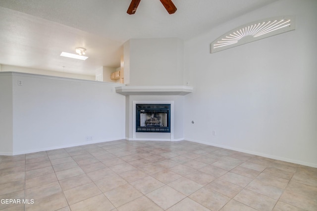 unfurnished living room featuring light tile patterned floors, a fireplace, baseboards, and a ceiling fan