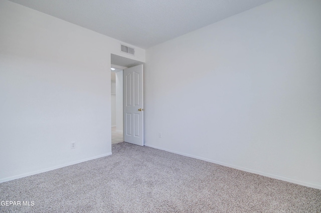 empty room with visible vents, baseboards, and carpet floors