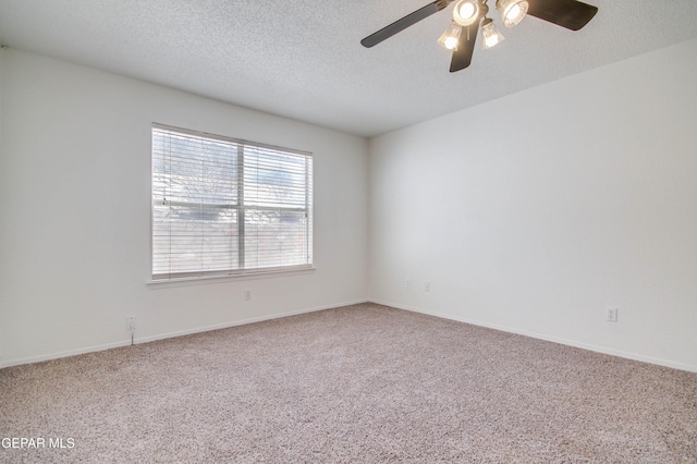 empty room featuring a ceiling fan, baseboards, a textured ceiling, and carpet flooring