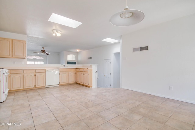 kitchen featuring visible vents, white appliances, a peninsula, and light brown cabinets