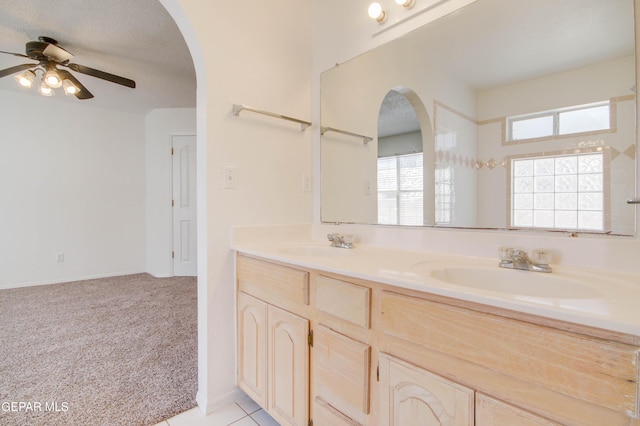 full bath featuring double vanity, a ceiling fan, and a sink