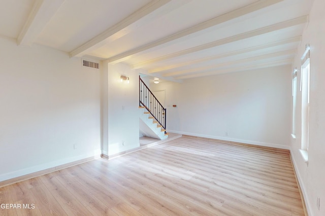 spare room featuring stairway, beamed ceiling, visible vents, and light wood-type flooring