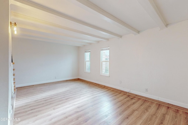 spare room with baseboards, beam ceiling, light wood-style flooring, and stairs