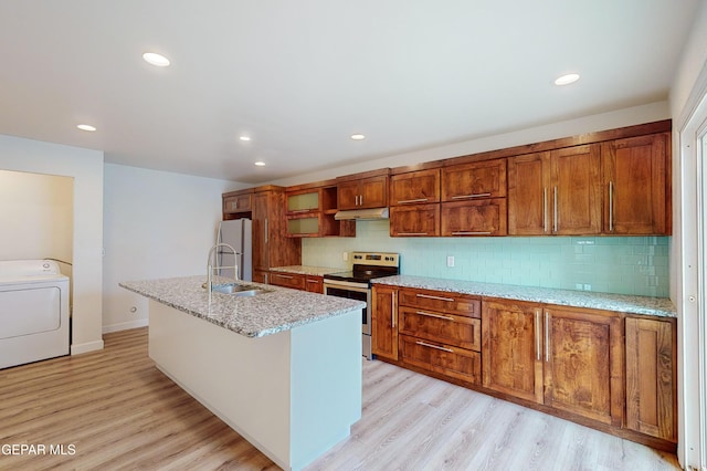 kitchen featuring under cabinet range hood, washer / dryer, light wood-style floors, electric range, and a sink