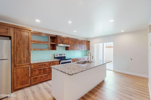 kitchen with under cabinet range hood, light wood-style flooring, appliances with stainless steel finishes, and a sink