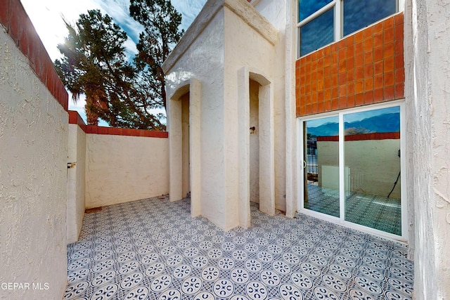 doorway to property with fence and stucco siding