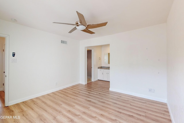 empty room featuring visible vents, ceiling fan, baseboards, and light wood-style floors