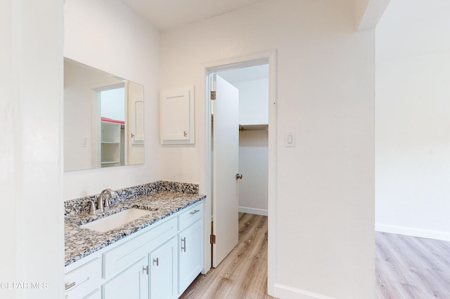 bathroom featuring vanity, baseboards, and wood finished floors