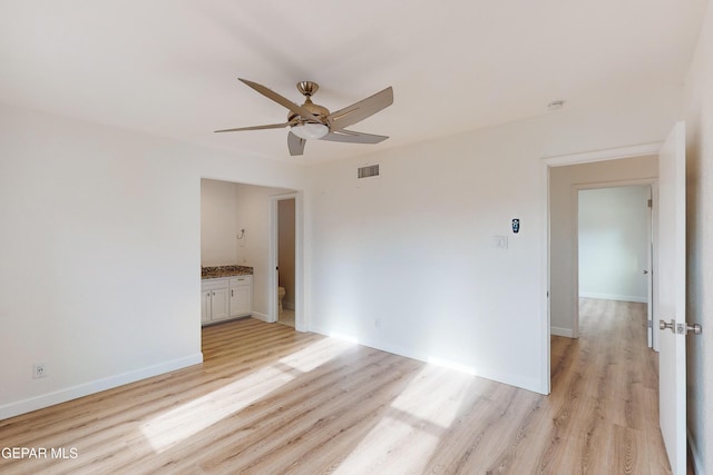 spare room featuring baseboards, light wood-style floors, visible vents, and ceiling fan