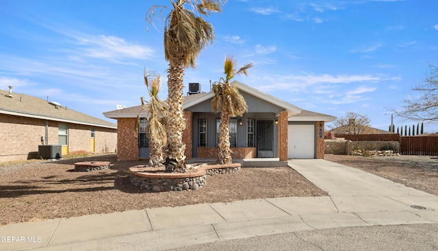 ranch-style home with central AC unit, concrete driveway, an attached garage, fence, and brick siding