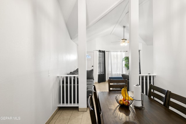 dining space featuring a ceiling fan, vaulted ceiling, baseboards, and light tile patterned floors