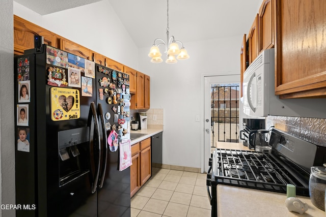 kitchen with lofted ceiling, light tile patterned floors, light countertops, black appliances, and brown cabinetry