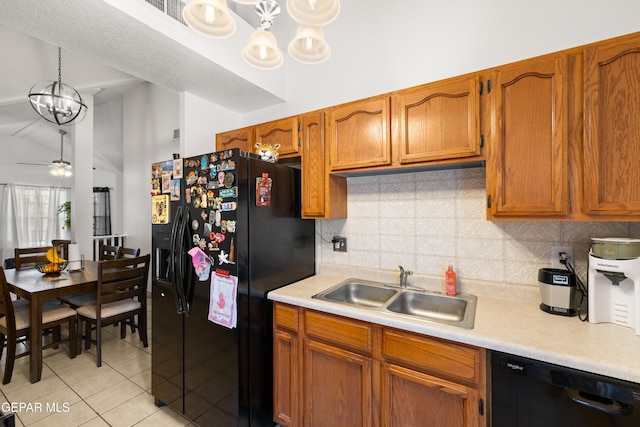 kitchen with a sink, vaulted ceiling, light countertops, backsplash, and black appliances