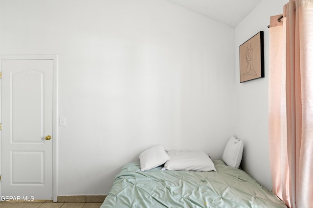 bedroom featuring lofted ceiling and light tile patterned floors