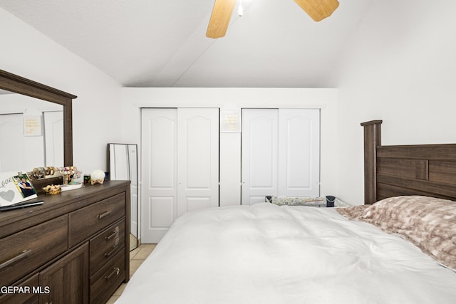 bedroom featuring vaulted ceiling, a ceiling fan, and multiple closets