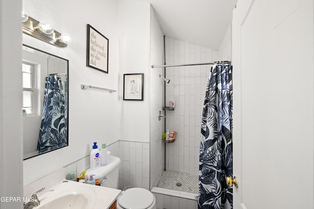 full bath with toilet, lofted ceiling, vanity, a shower stall, and tile walls